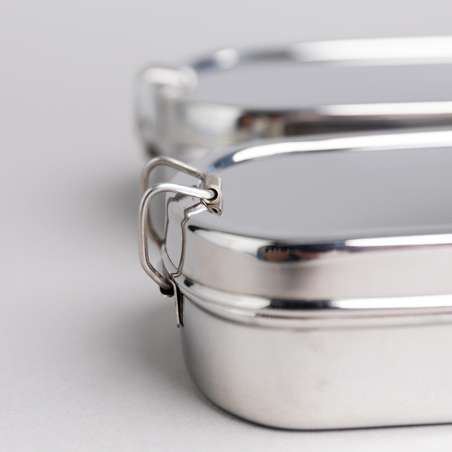 Close up of a stainless steel clip of a lunch box with compartments