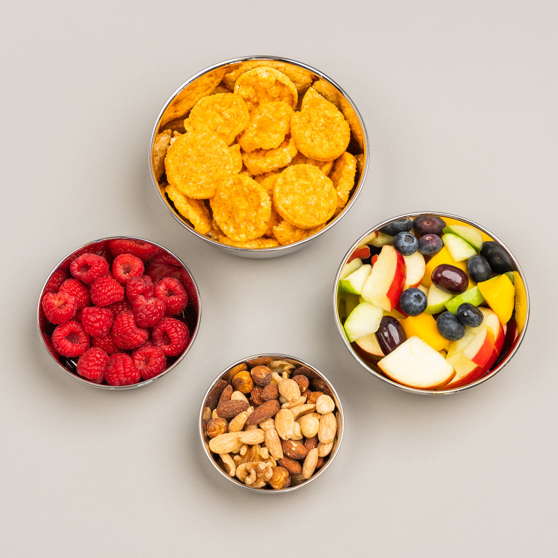 4 stainless steel bowls filled with food