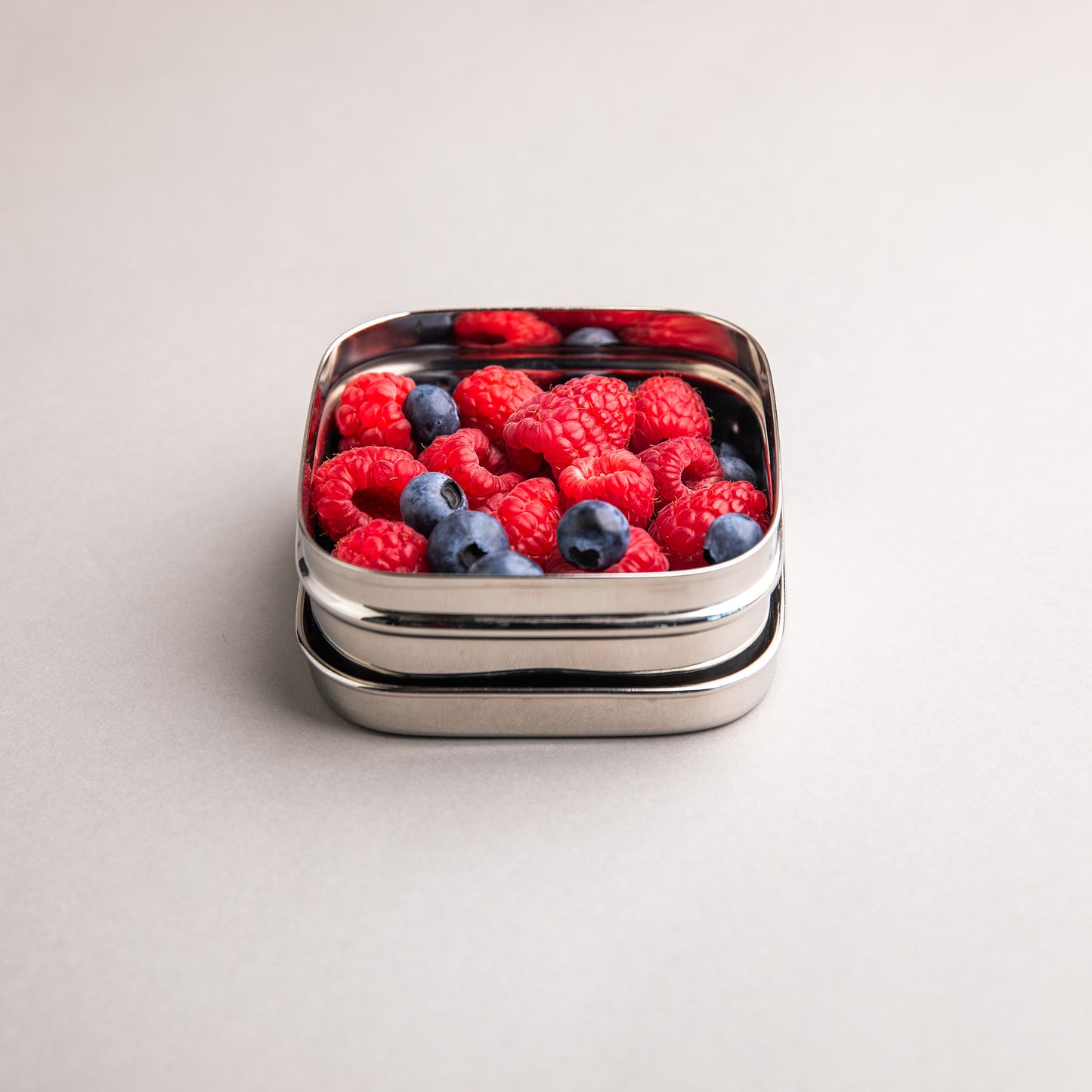 Stainless steel fruit bowl filled with raspberries