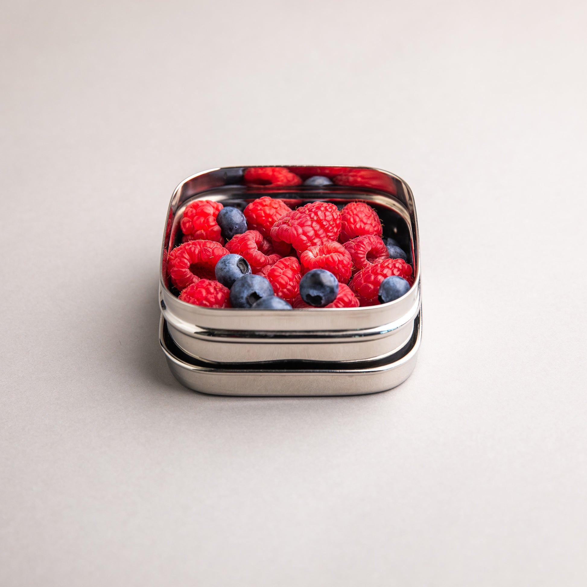 Stainless steel fruit bowl filled with raspberries
