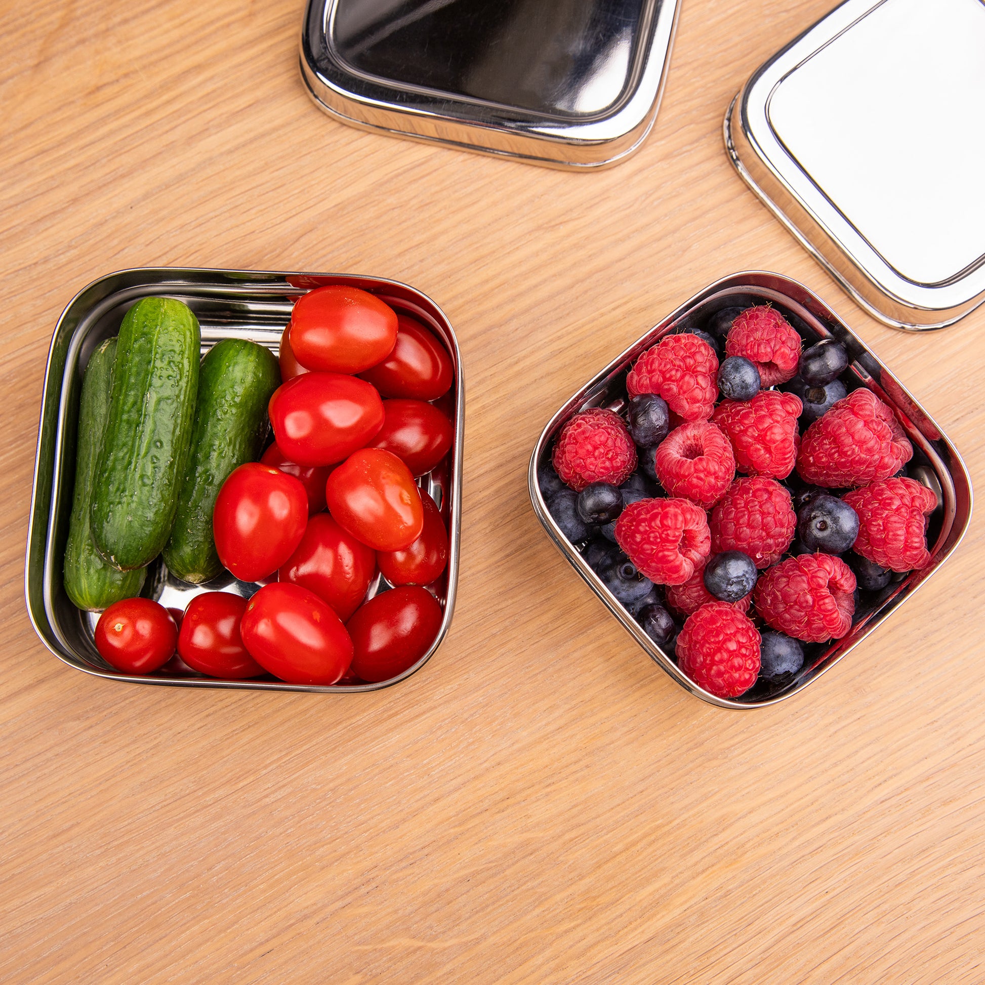 Stainless steel fruit bowls on a school table with vegetables and fruit