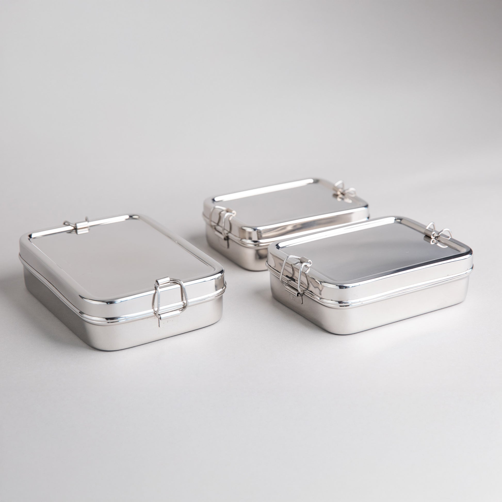 Stainless steel lunch boxes in 3 sizes next to each other on a white background
