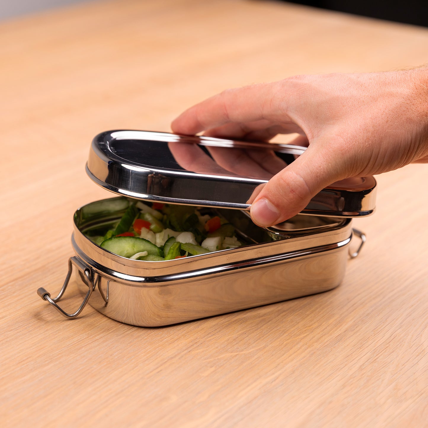 Stainless steel lunch box with compartments that is opened by one hand