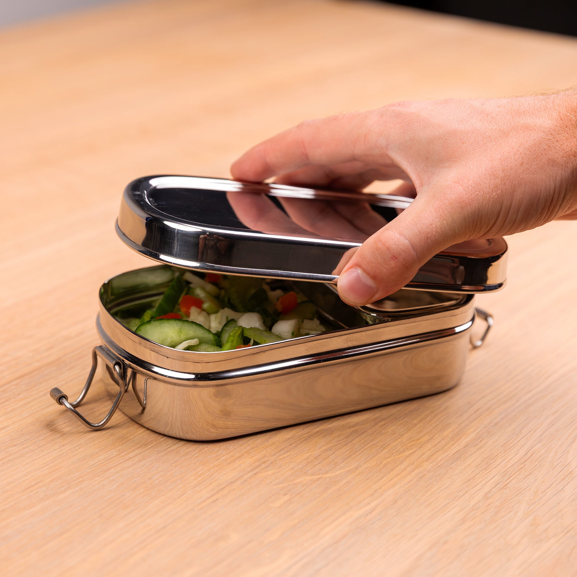 Stainless steel lunch box with compartments that is opened by one hand