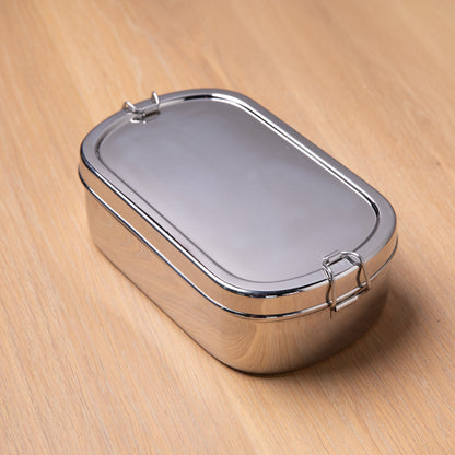 Stainless steel lunch box for adults on a wooden surface