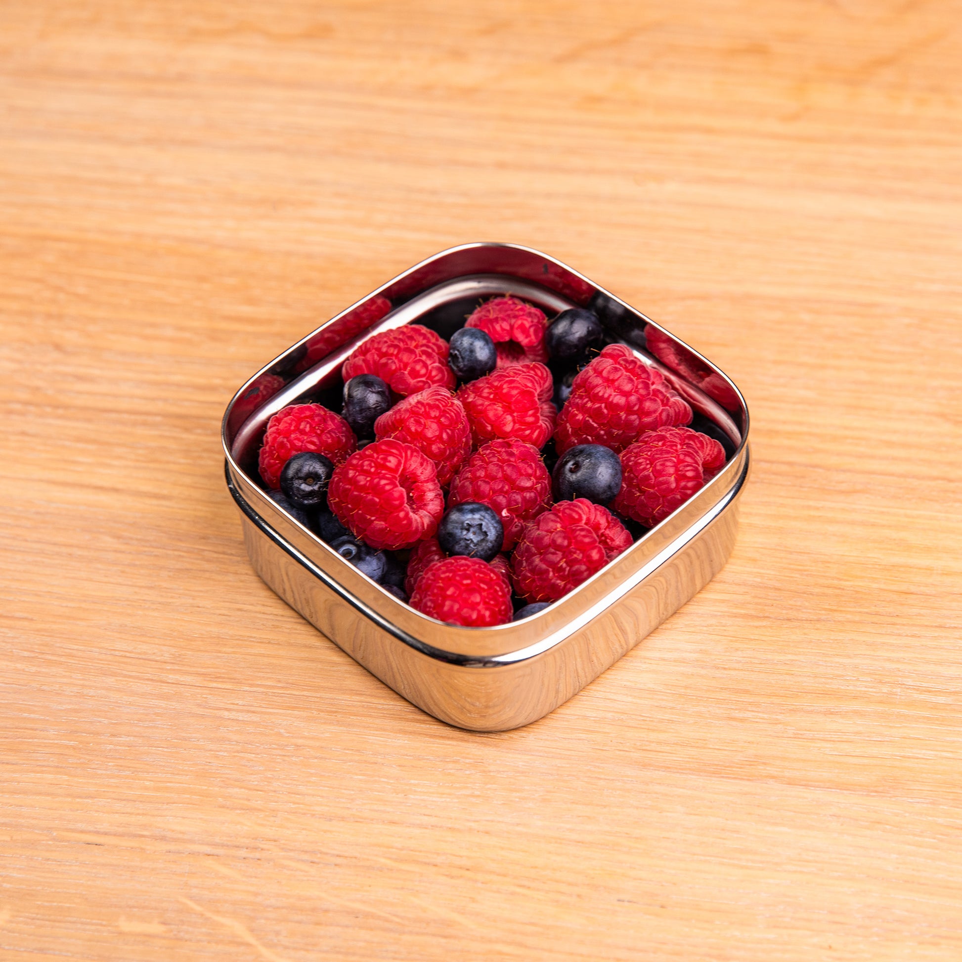 Stainless steel snack box filled with raspberry