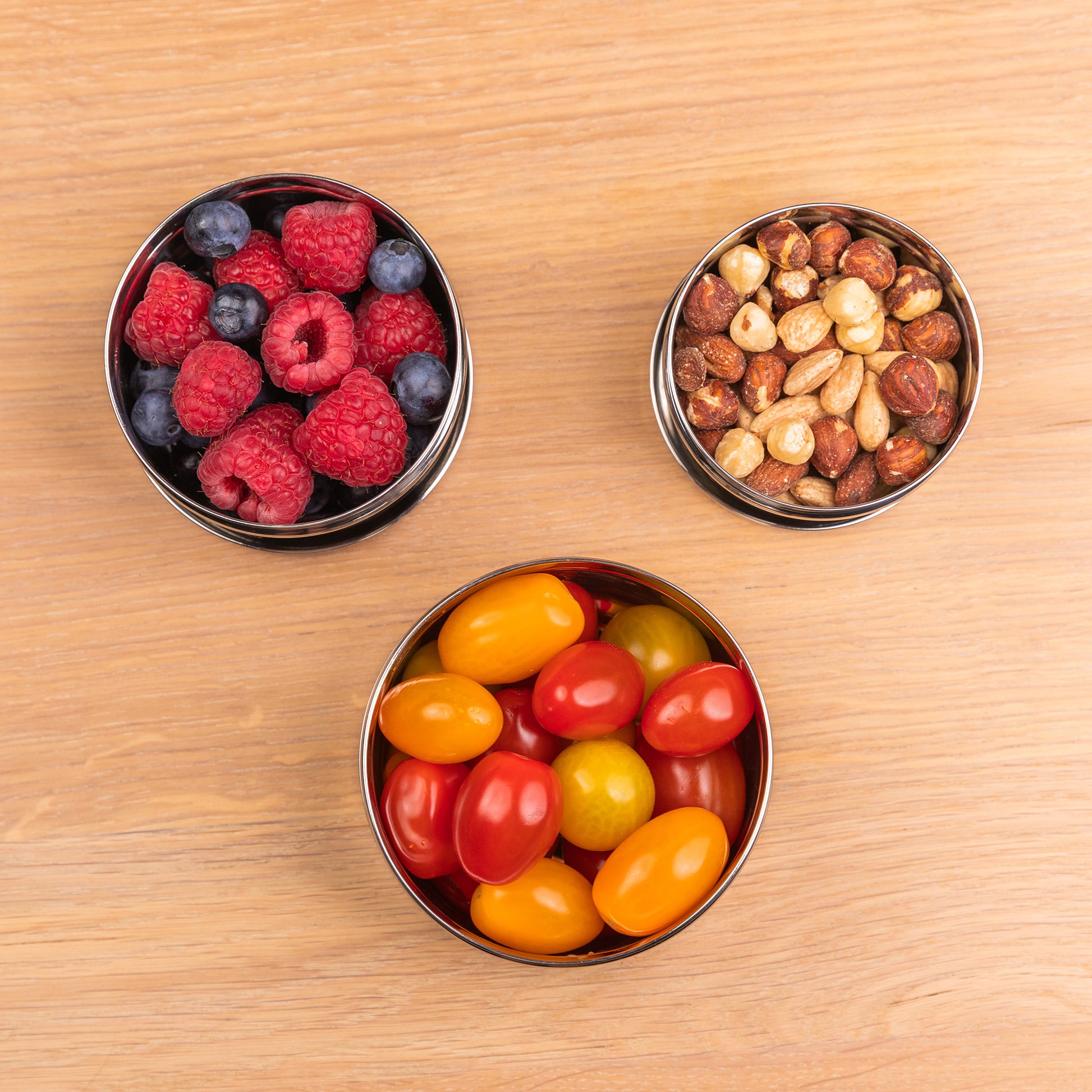 Stainless steel snack boxes filled with nuts and tomatoes