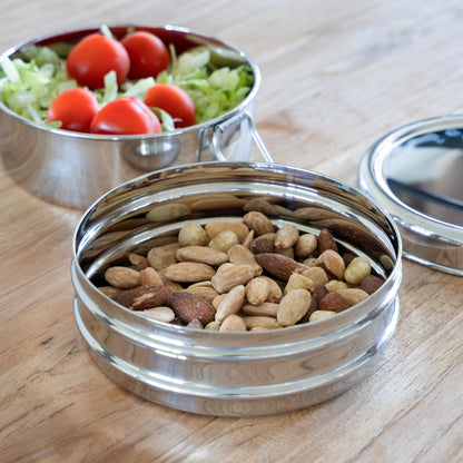 Round stainless steel bento box with nuts and tomatoes
