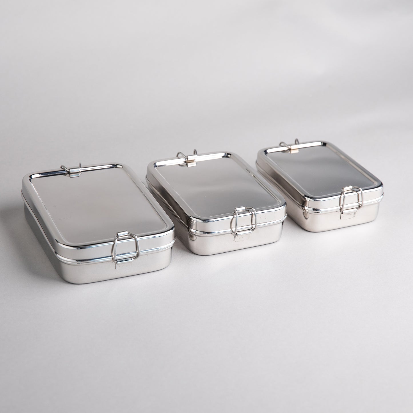 Stainless steel lunch boxes in 3 sizes next to each other