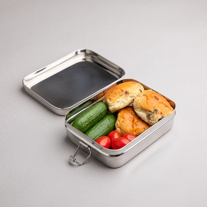 small stainless steel lunch box filled with currant buns, cucumber and tomato