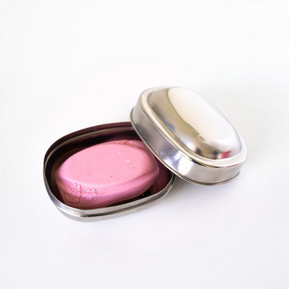 open stainless steel soap dish with a soap bar in it