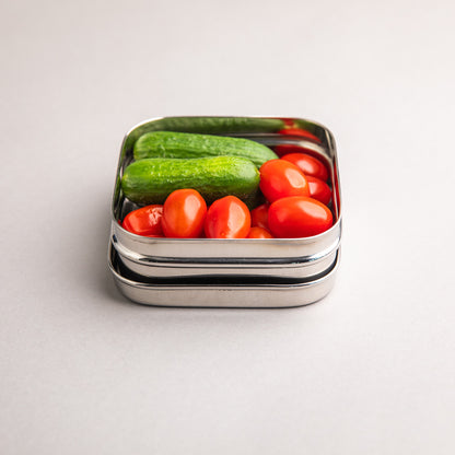 Stainless steel snack box filled with healthy snacks such as cucumber
