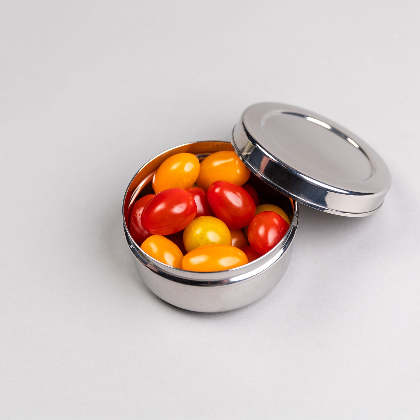 Large stainless steel snack box filled with tomatoes