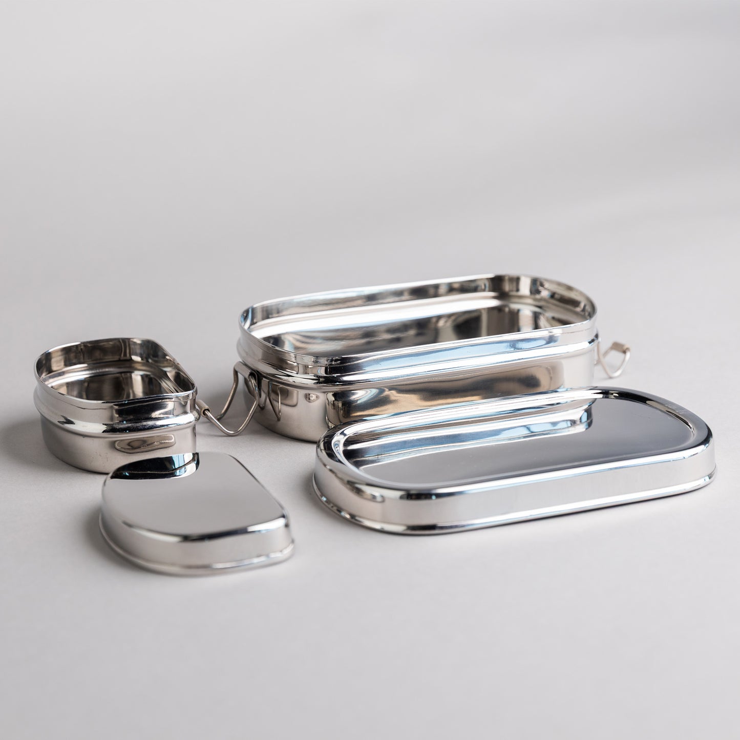 Stainless steel lunch box with snack box opened on gray background