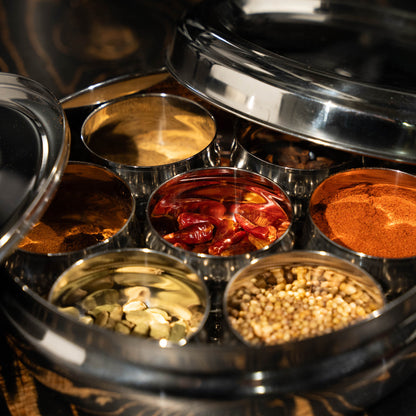 close up of a masala dabba filled with spices 