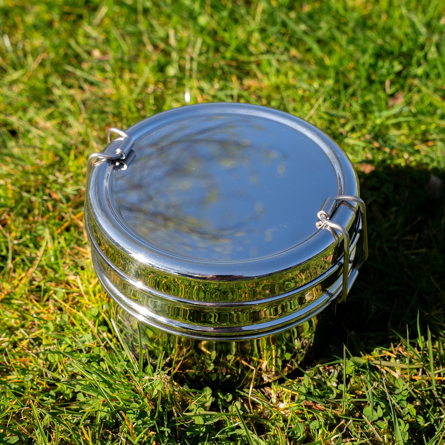 round stainless steel bento box on grass