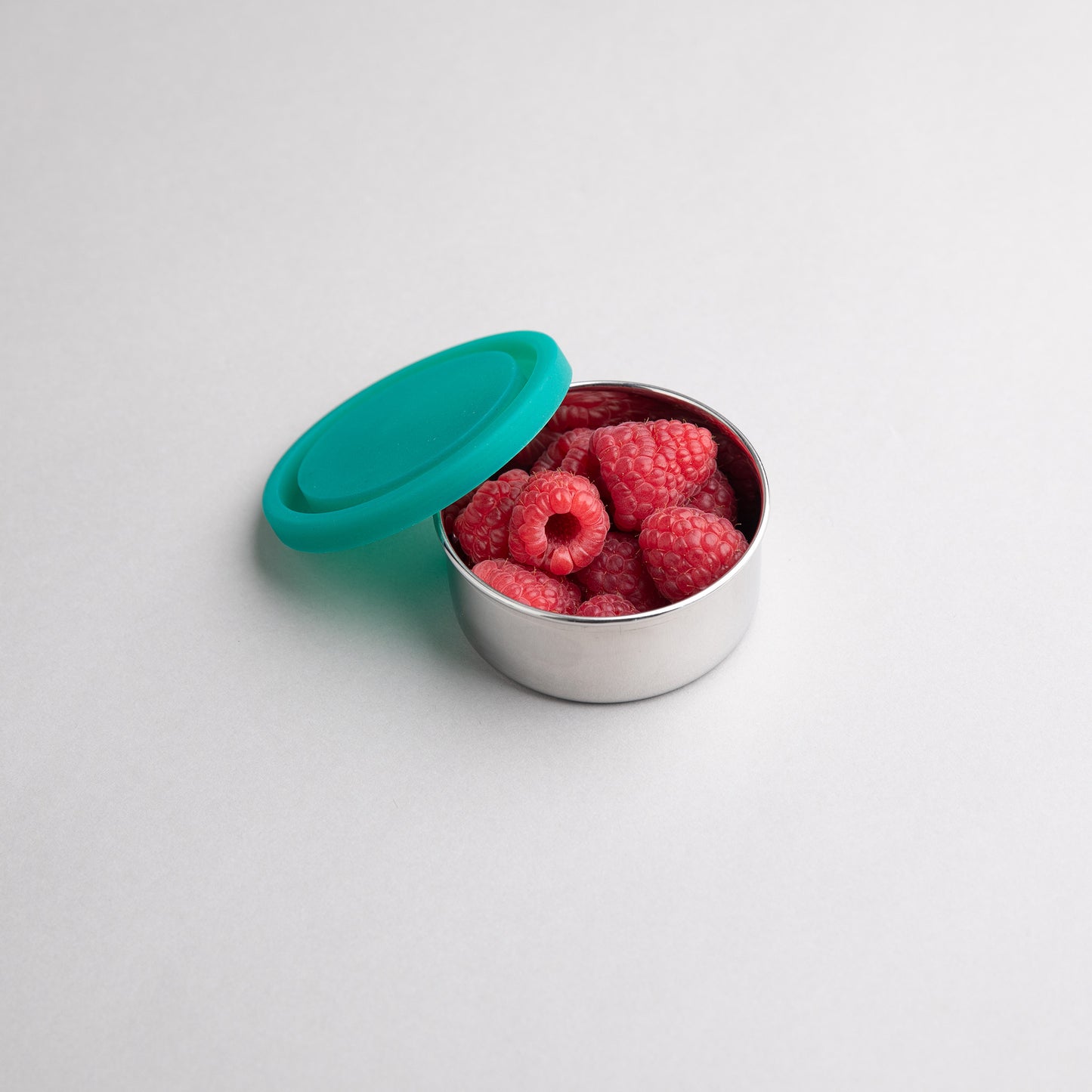 snack box with silicone lid filled with raspberries